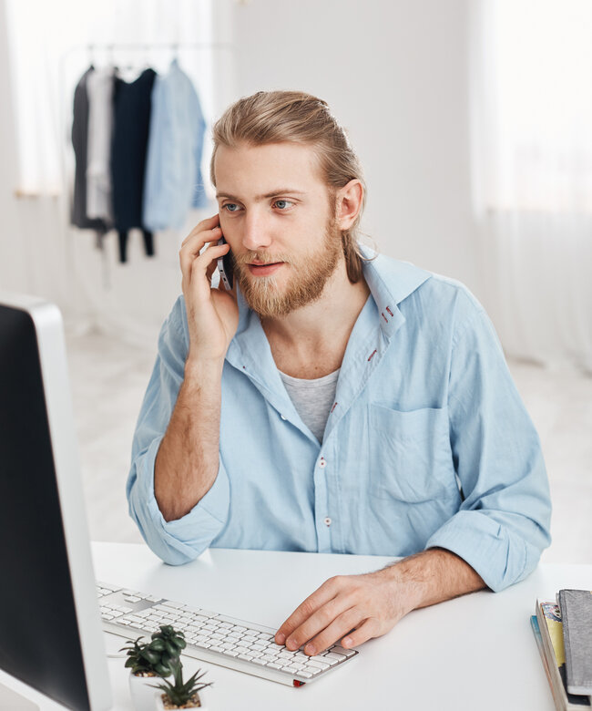 E-Commerce Manager führt ein Telefongespräch mit Kunden und arbeitet am Computer im Online-Handel