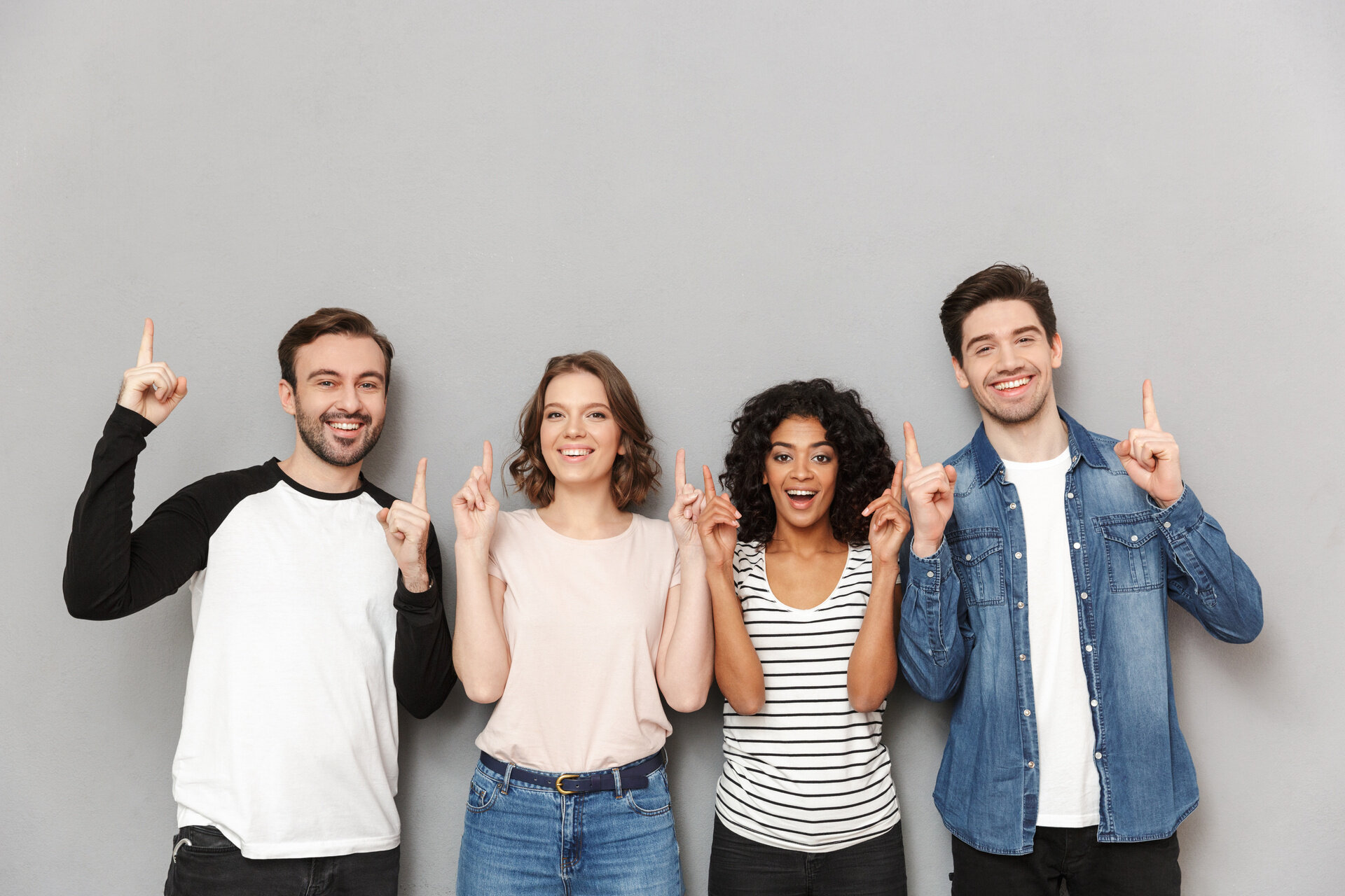 Gruppe junger Erwachsener zeigt nach oben und steht für berufliche Umschulung und neue Perspektiven