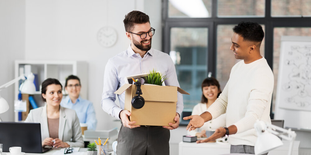 Beruf wechseln und neu starten im Job – Möglichkeiten und Chancen Mann beim Jobwechsel im Büro mit Umzugskarton und Kollegen