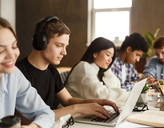 Lerntypen und Lernmethoden beim Online-Lernen Erwachsene Lernende arbeiten mit Laptop und Kopfhörern in einer gemeinsamen Lernumgebung