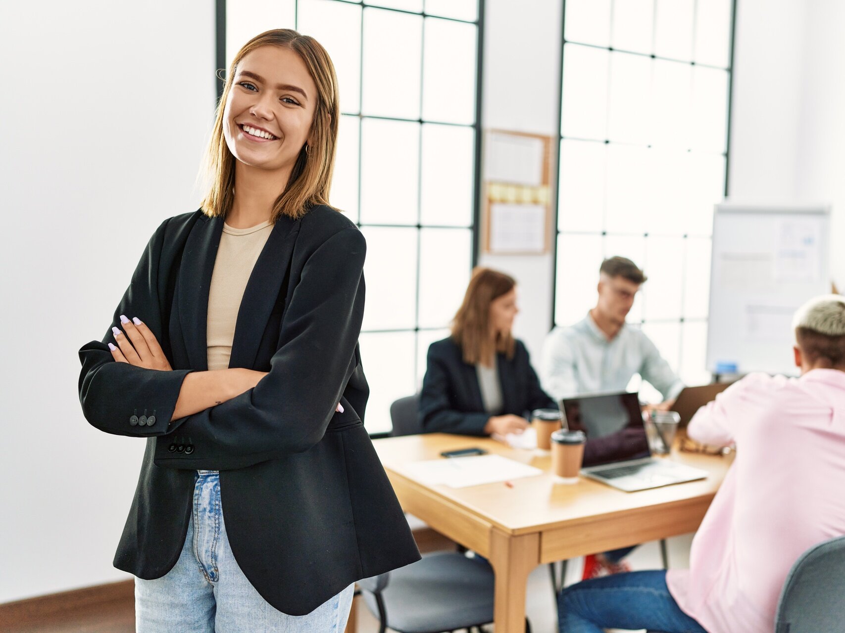 Office-Managerin steht vor einem Team in einem modernen Büro