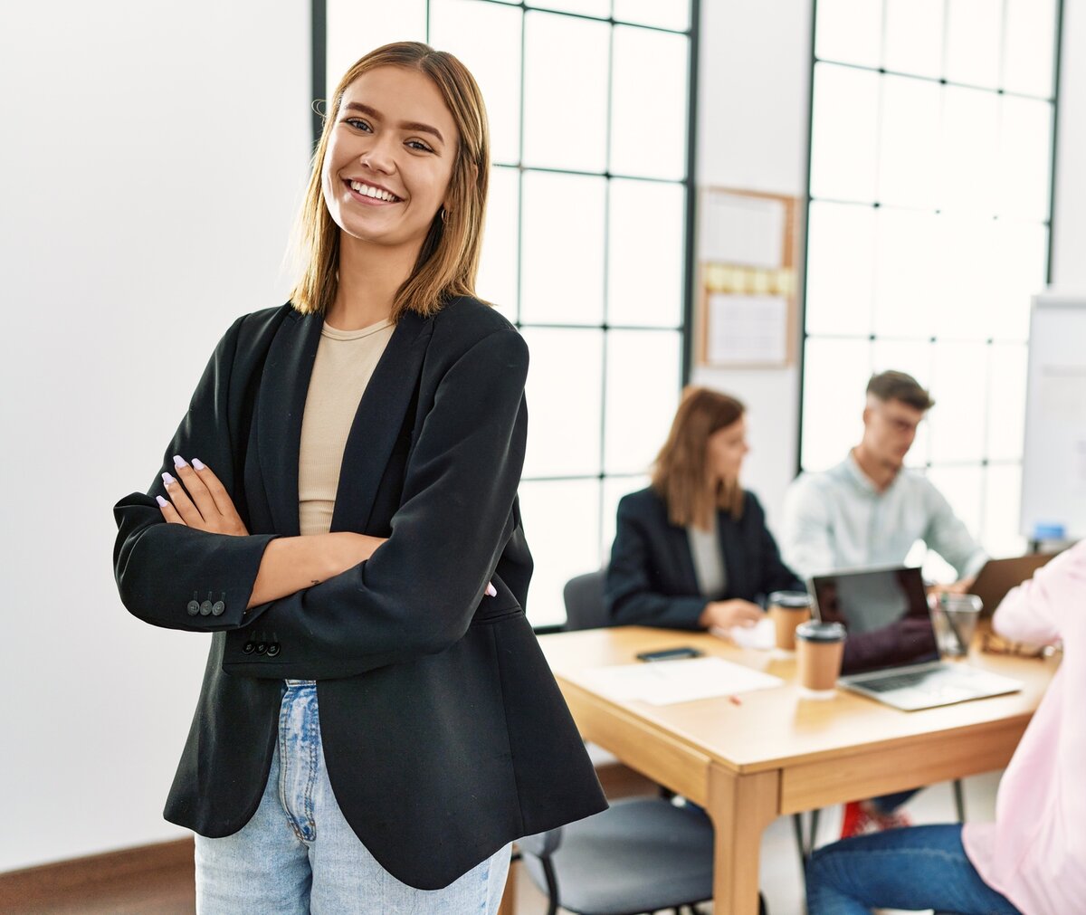Office-Managerin steht vor einem Team in einem modernen Büro