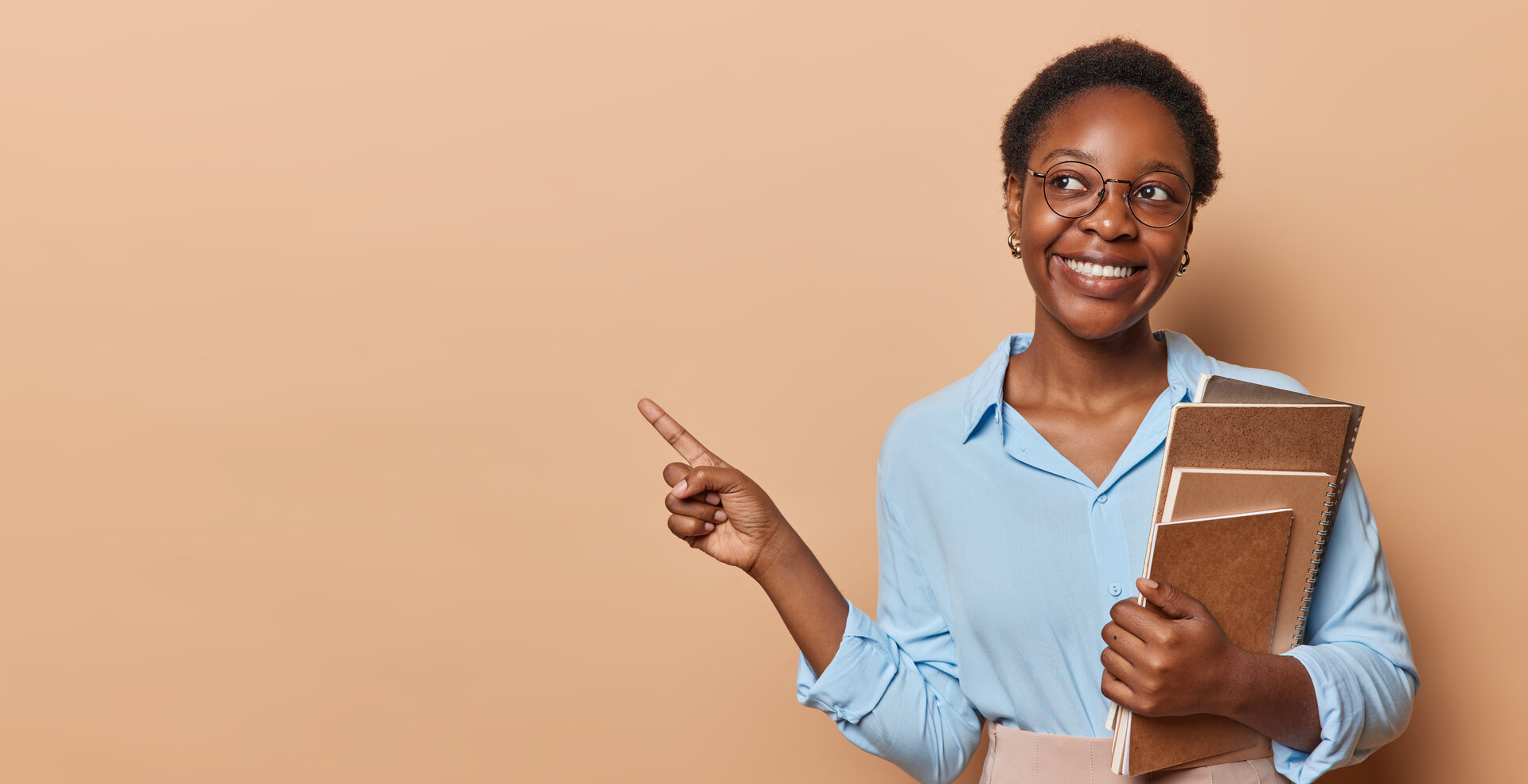 Frau mit Unterlagen zeigt zur Seite und steht für Umschulung und beruflichen Neustart