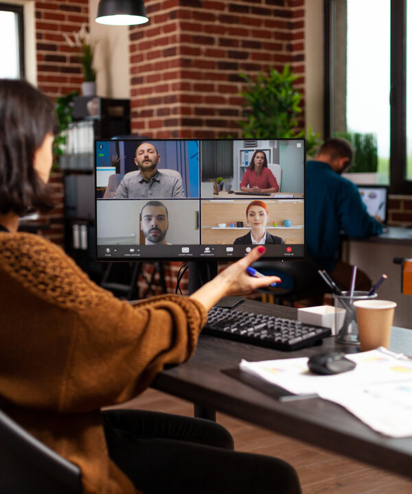 Teilnehmende kommunizieren in einer Videokonferenz während einer Online-Weiterbildung