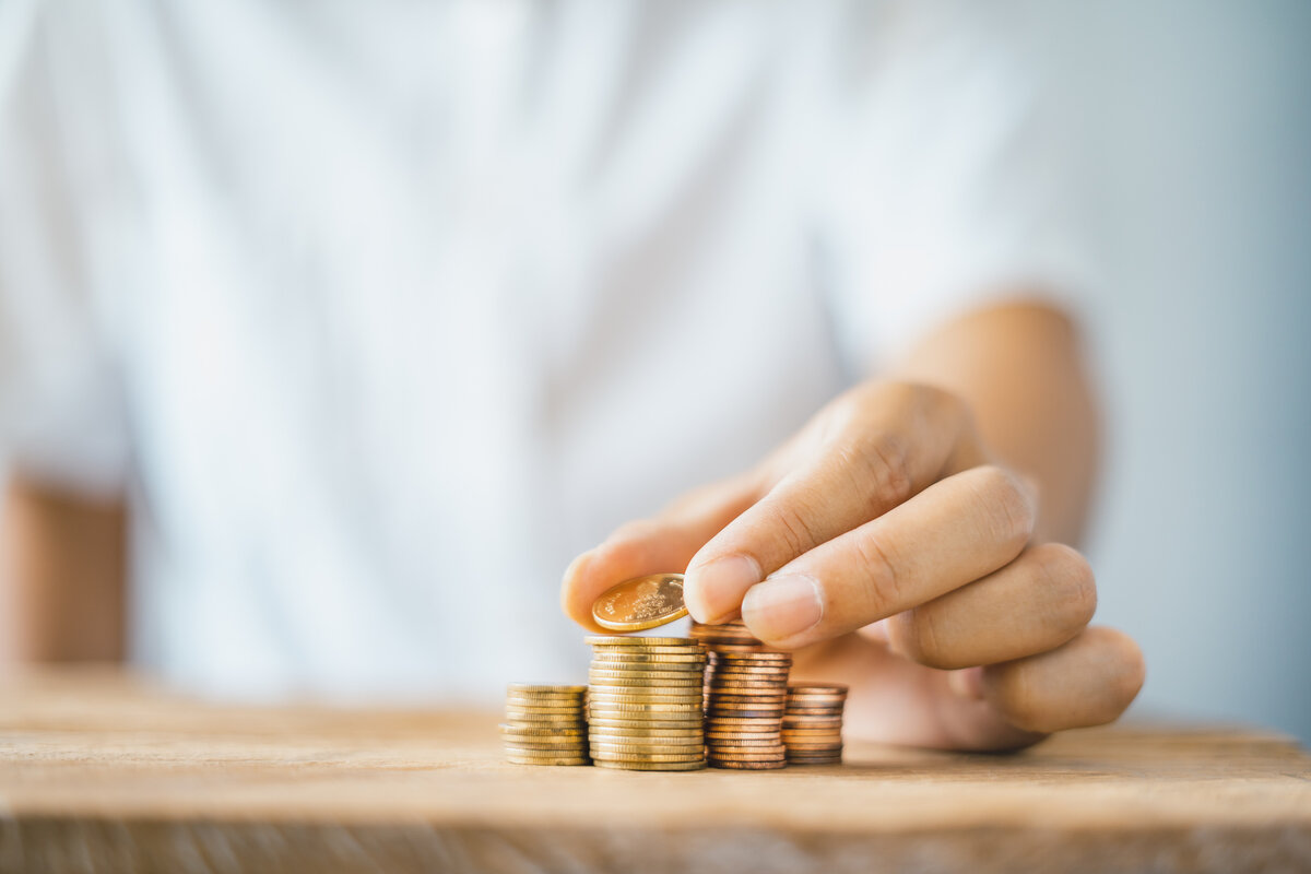 Förderung für Weiterbildung und Umschulung – Finanzierung & Zuschüsse Hand stapelt Münzen – Symbol für finanzielle Förderung von Weiterbildung und Umschulung