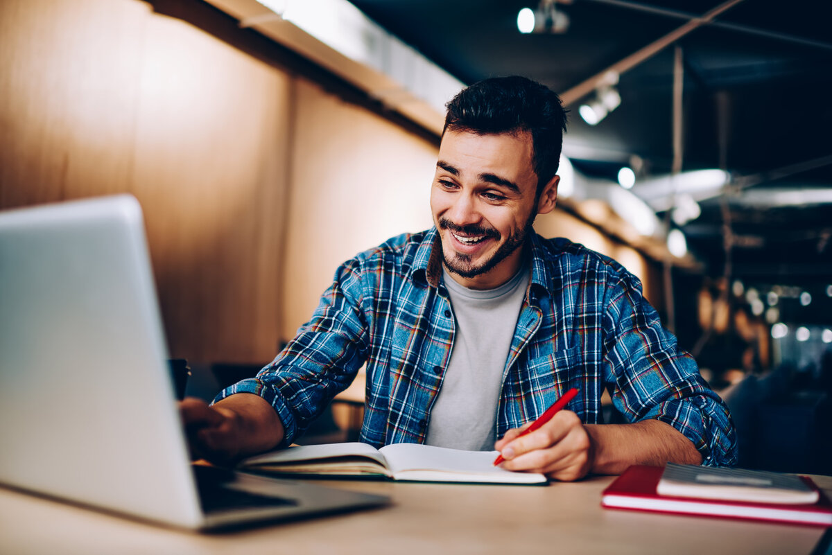 Weiterbildung in Grundkompetenzen und Vorbereitung Mann lernt mit Laptop und Notizbuch an einem modernen Arbeitsplatz